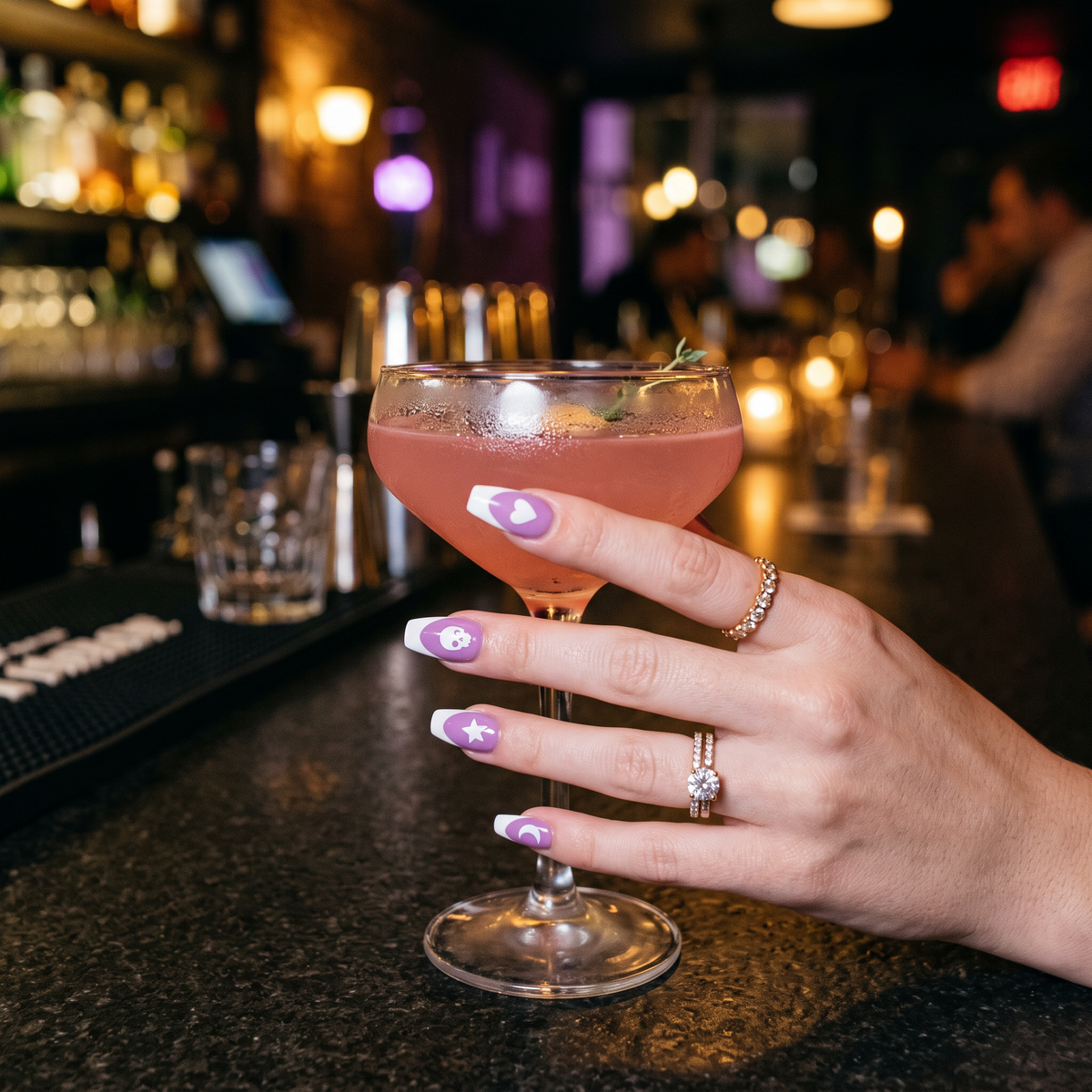 Ongles avec stickers NightKind tenant un cocktail